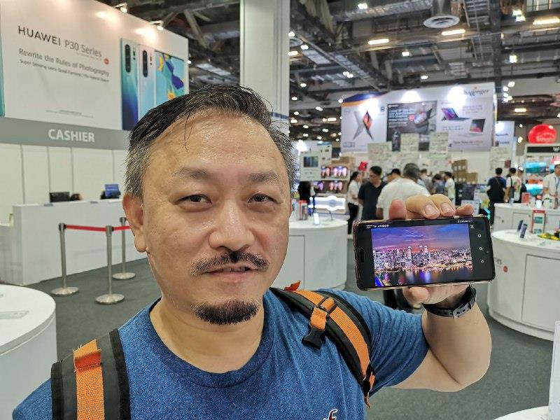 Mr. Wilson Ng holding a Huawei P20 Pro